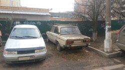 Автомобиль ВАЗ серого цвета на стоянке между домом №59 и №55 на улице Ленина.