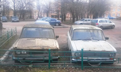 Два автомобиля марки ВАЗ белого и желтого цвета на стоянке возле дома №26 по улице Ленина.